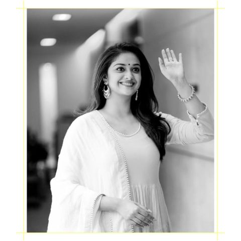 Keerthy Suresh in a white dress poses a picture.